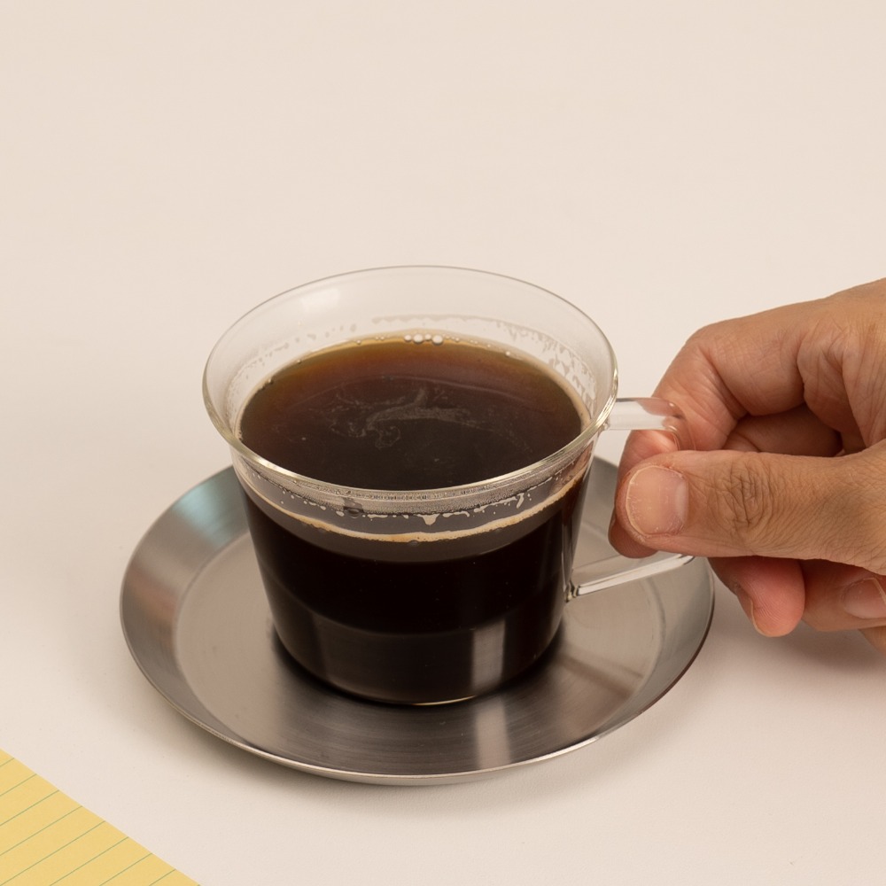 킨토 캐스트 내열유리 커피컵을 옆에서 바라본 모습, 투명한 유리로 만들어진 세련된 디자인이 돋보임